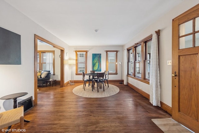 dining room featuring visible vents, baseboards, and dark wood-type flooring