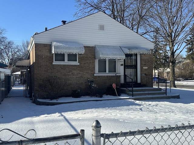 bungalow-style home with brick siding, fence, and a gate