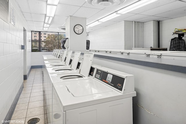 community laundry room with washing machine and dryer and light tile patterned floors
