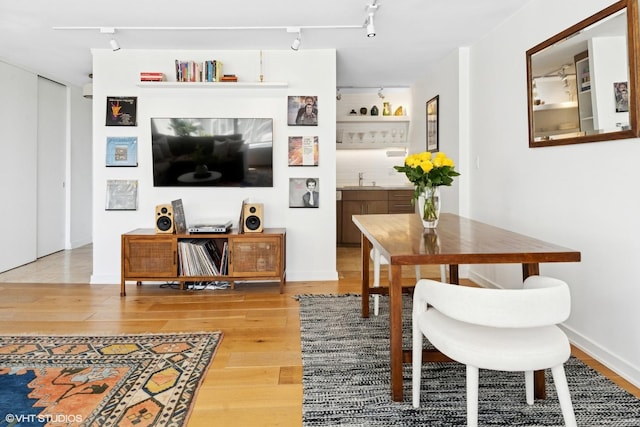 dining space featuring wood finished floors and rail lighting
