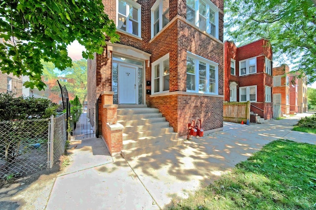 entrance to property with brick siding and fence