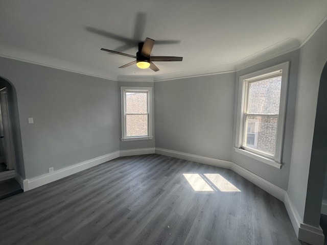 empty room with baseboards, ornamental molding, and wood finished floors