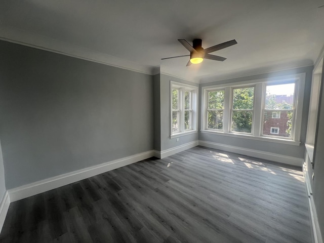 spare room featuring a ceiling fan, baseboards, dark wood finished floors, and crown molding