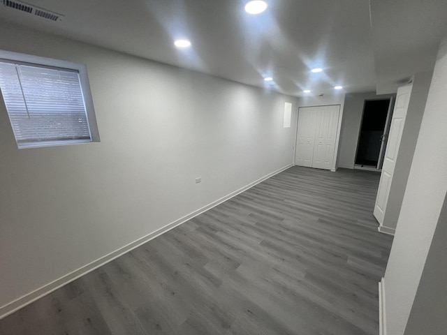 below grade area featuring dark wood-style floors, recessed lighting, visible vents, and baseboards