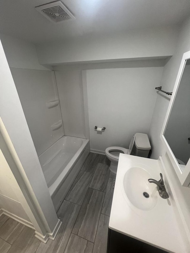 bathroom featuring wood tiled floor, visible vents, vanity, and toilet