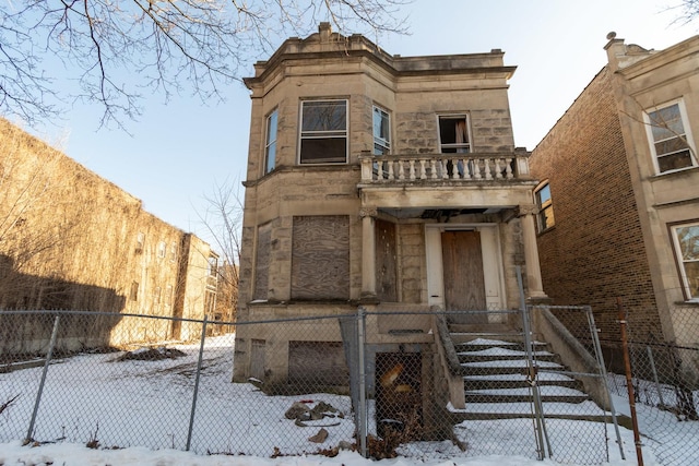 3827 W Gladys Ave, Chicago, IL 60624 - view of front of home with stone siding, a fenced front yard, and a balcony