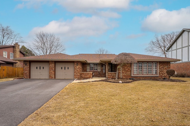 ranch-style home featuring brick siding, fence, aphalt driveway, a front yard, and an attached garage