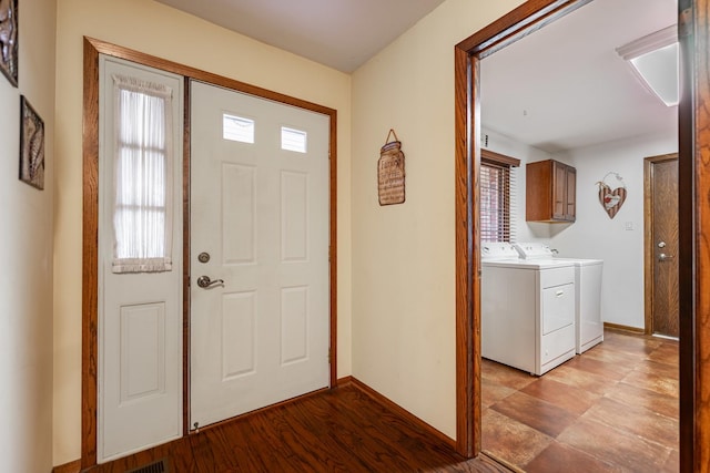 foyer entrance with light wood-style flooring, baseboards, and washing machine and clothes dryer