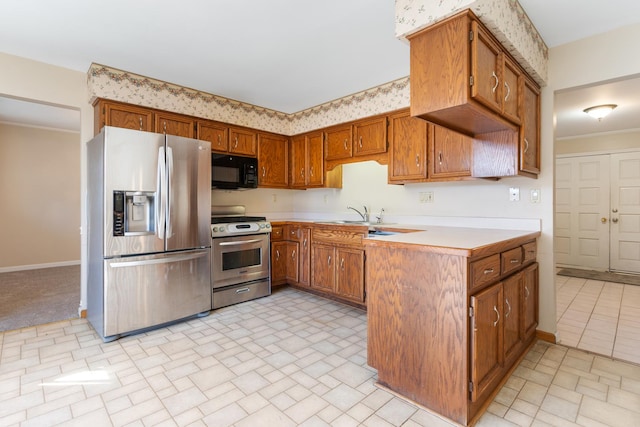 kitchen featuring baseboards, stainless steel appliances, light countertops, and brown cabinets