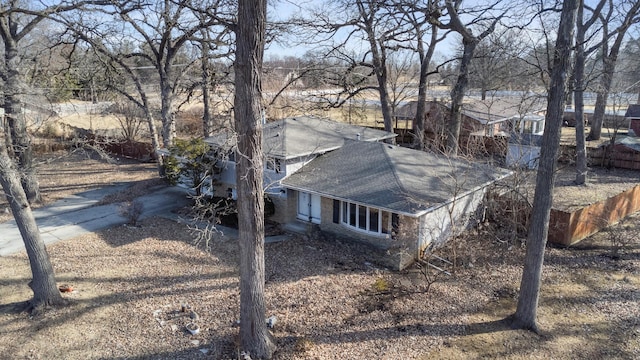 view of property exterior featuring a shingled roof and fence