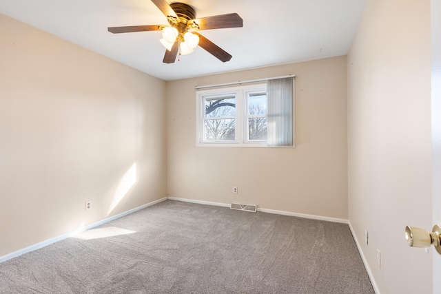 carpeted spare room with ceiling fan, visible vents, and baseboards