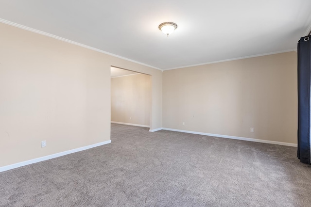 spare room with ornamental molding, carpet flooring, and baseboards