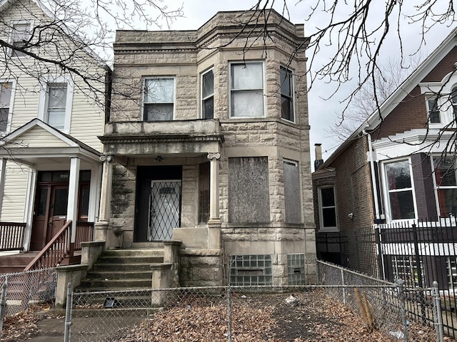 view of front of house featuring stone siding and a fenced front yard