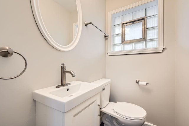 half bathroom with vanity and toilet