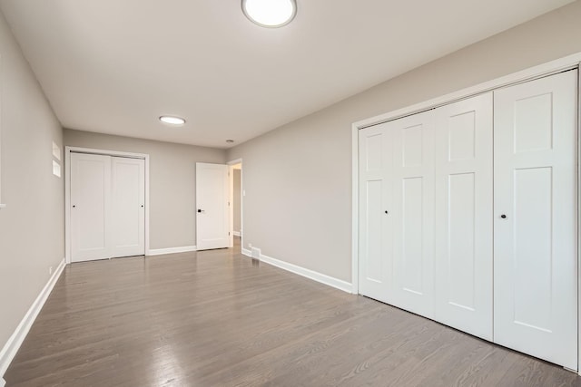 unfurnished bedroom with baseboards and wood finished floors