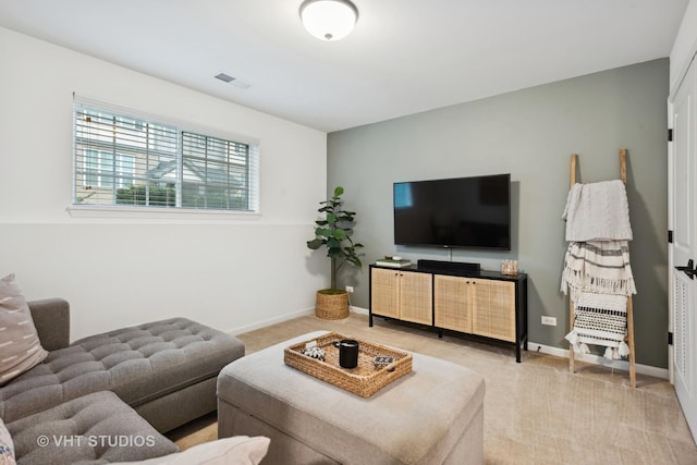 carpeted living area featuring visible vents and baseboards