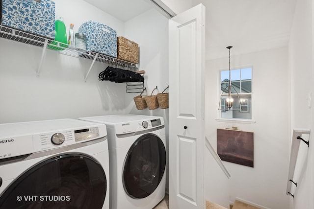 laundry room featuring laundry area, washing machine and clothes dryer, and an inviting chandelier