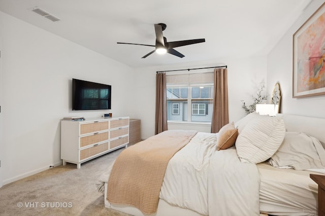 bedroom with light carpet, ceiling fan, visible vents, and baseboards