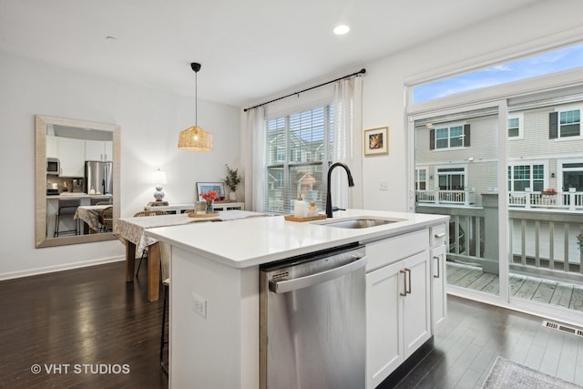 kitchen featuring white cabinets, appliances with stainless steel finishes, dark wood-type flooring, and a sink