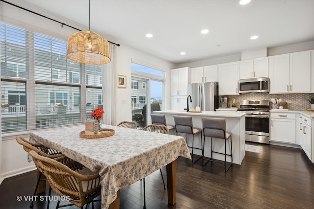 kitchen featuring dark wood-style floors, tasteful backsplash, light countertops, appliances with stainless steel finishes, and white cabinetry