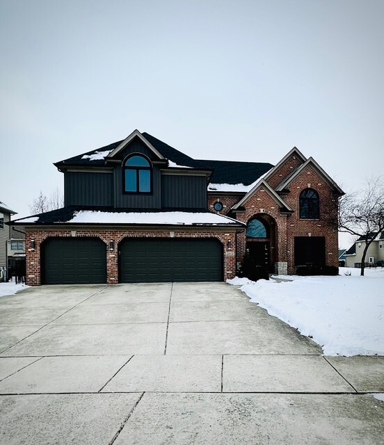 view of front of property with concrete driveway, brick siding, and an attached garage