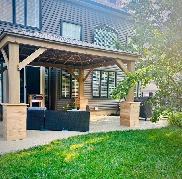 exterior space featuring metal roof, a patio, outdoor lounge area, a lawn, and a standing seam roof