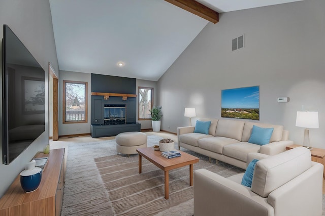 living room featuring high vaulted ceiling, visible vents, baseboards, beam ceiling, and a glass covered fireplace