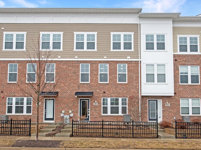 view of property with a fenced front yard and brick siding