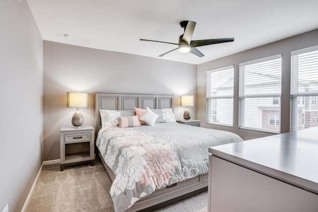 bedroom featuring baseboards, ceiling fan, and light colored carpet