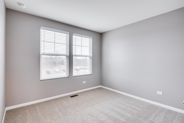 carpeted spare room with baseboards and visible vents