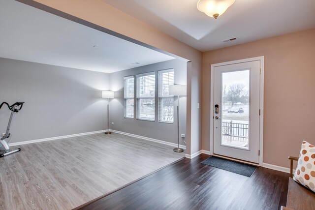 interior space with dark wood-type flooring, visible vents, and baseboards