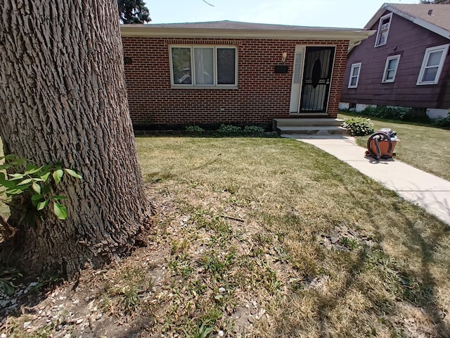 single story home with brick siding and a front lawn