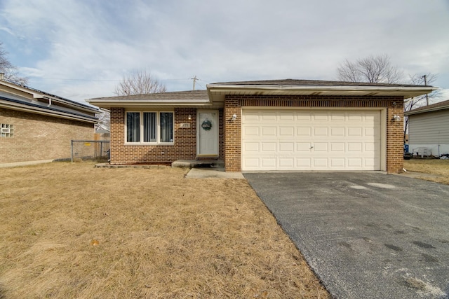 ranch-style house featuring a garage, aphalt driveway, a front lawn, and brick siding