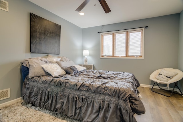 bedroom with visible vents, baseboards, and wood finished floors