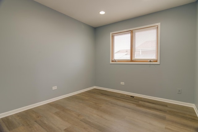 spare room with recessed lighting, visible vents, baseboards, and wood finished floors