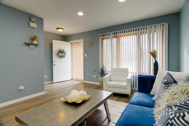 living area with recessed lighting, wood finished floors, and baseboards