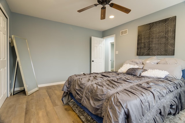 bedroom with baseboards, visible vents, ceiling fan, and wood finished floors