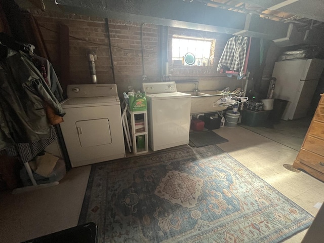 laundry room featuring laundry area, independent washer and dryer, a sink, and tile patterned floors