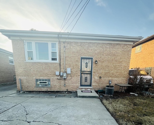 exterior space with brick siding and central AC unit