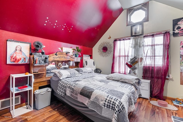 bedroom featuring lofted ceiling, wood finished floors, visible vents, and baseboards