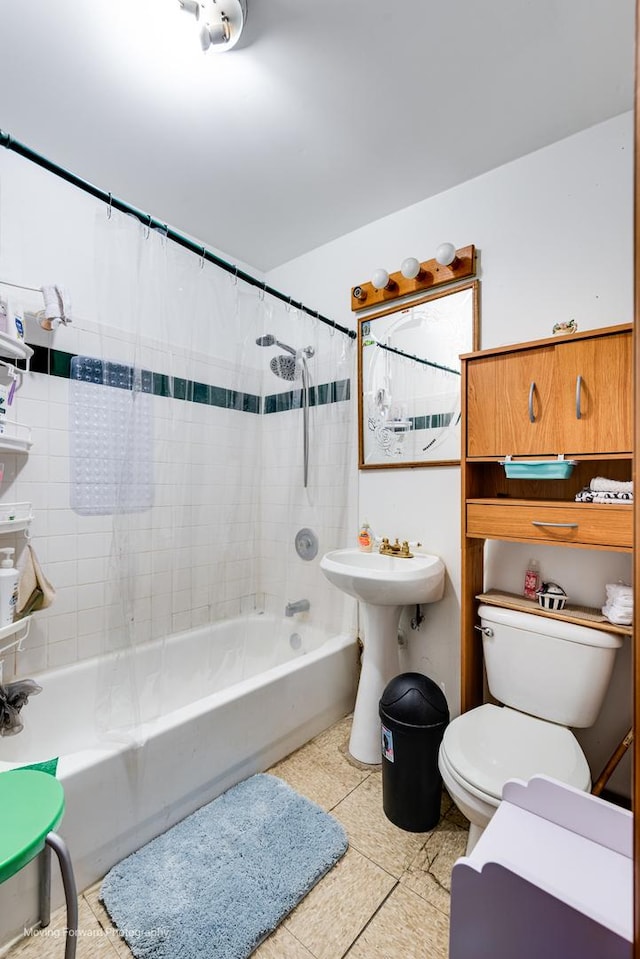 bathroom featuring a sink, tile patterned flooring, toilet, and shower / tub combo with curtain