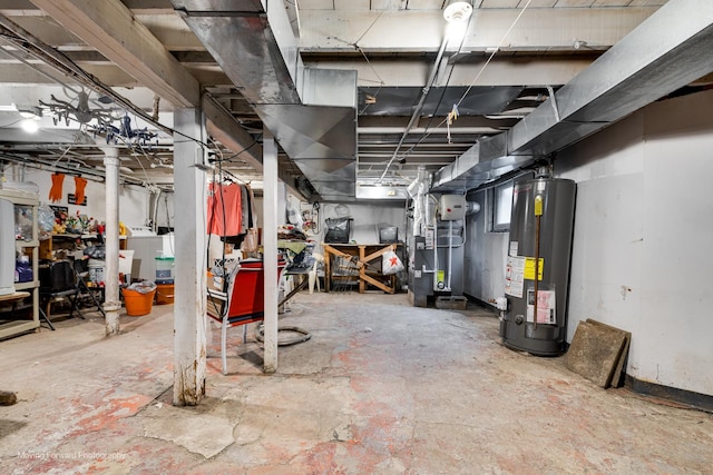 unfinished below grade area featuring a heating unit, washer / clothes dryer, and gas water heater