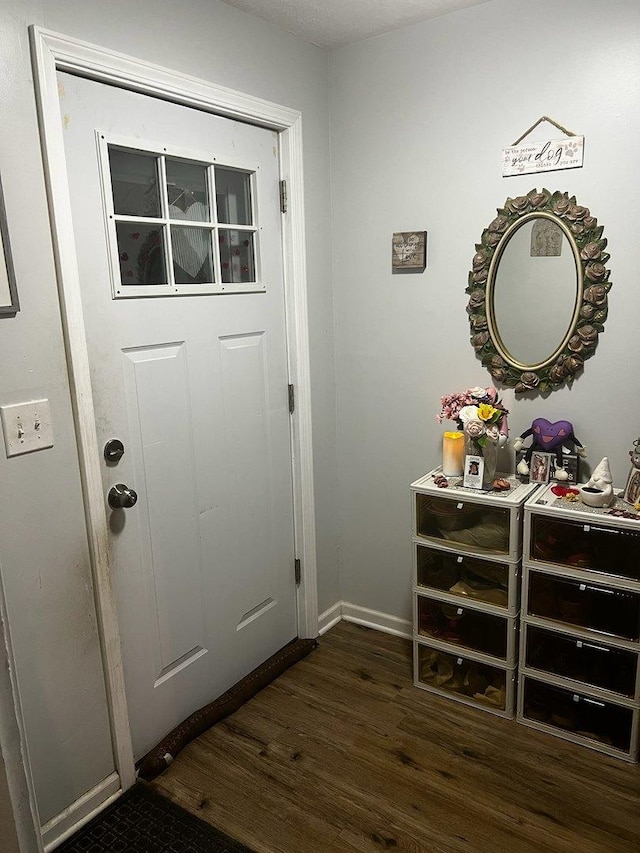 entryway with dark wood-style floors and baseboards