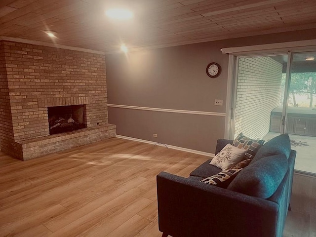 living room featuring wood ceiling, a fireplace, crown molding, and wood finished floors