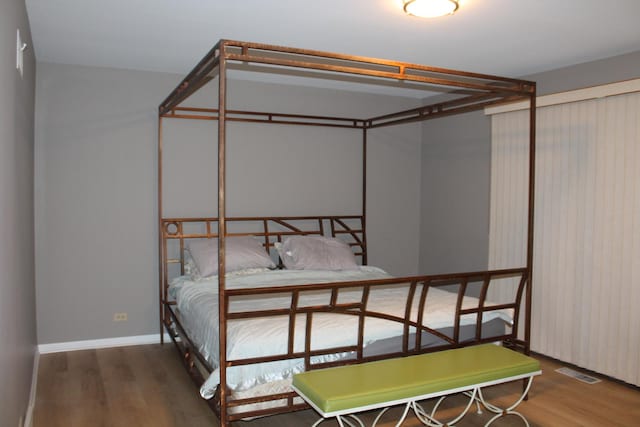 bedroom with visible vents and wood finished floors