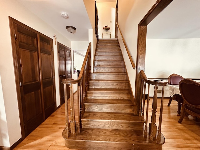 stairway featuring wood-type flooring and baseboards