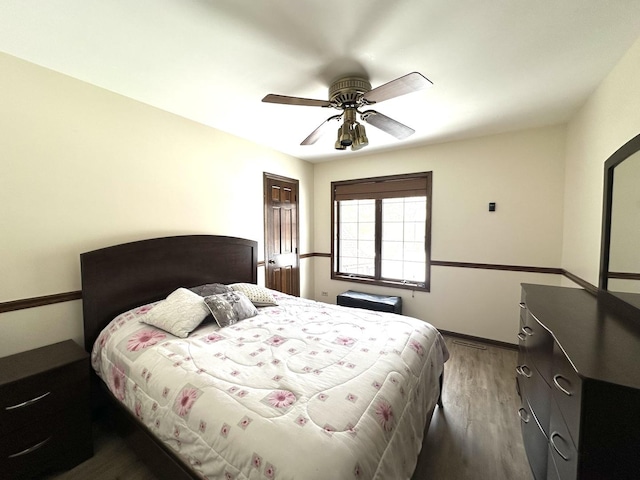 bedroom featuring a ceiling fan, baseboards, and wood finished floors