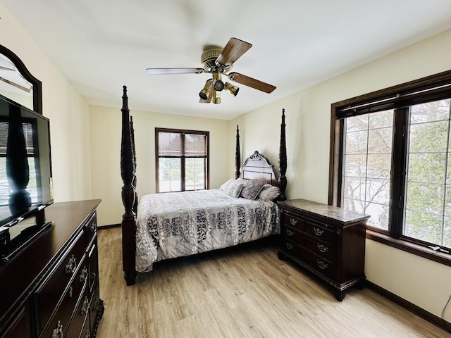 bedroom with light wood-style flooring, baseboards, and ceiling fan