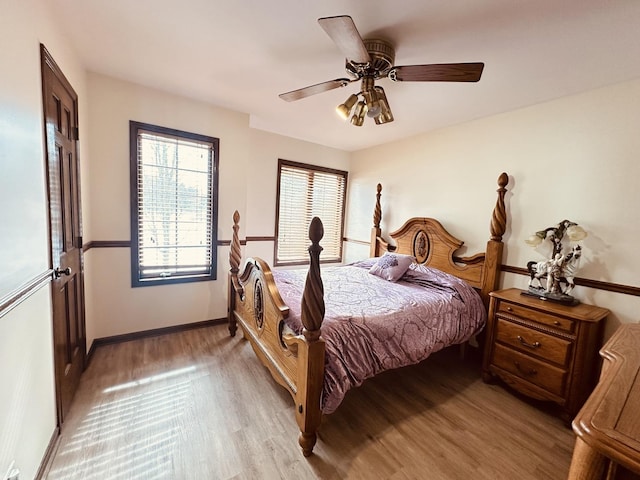 bedroom featuring light wood-type flooring, baseboards, and a ceiling fan