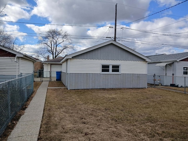 view of property exterior with a detached garage, fence, and a lawn